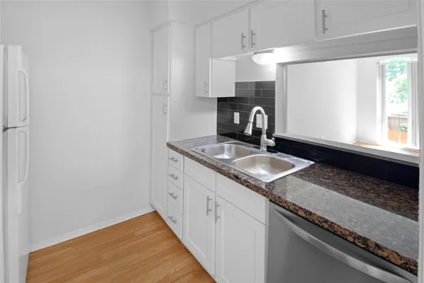 a kitchen with granite countertop a sink a stove and cabinets