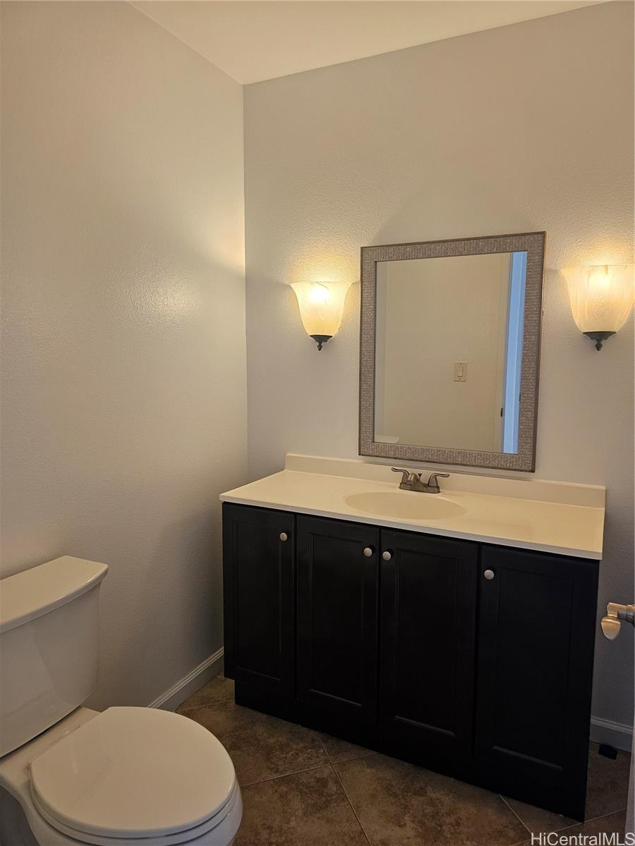 91-1040 Kanihaalilo Street Kapolei, HI 96707 - Photo 11 of 12 a bathroom with a toilet sink and mirror