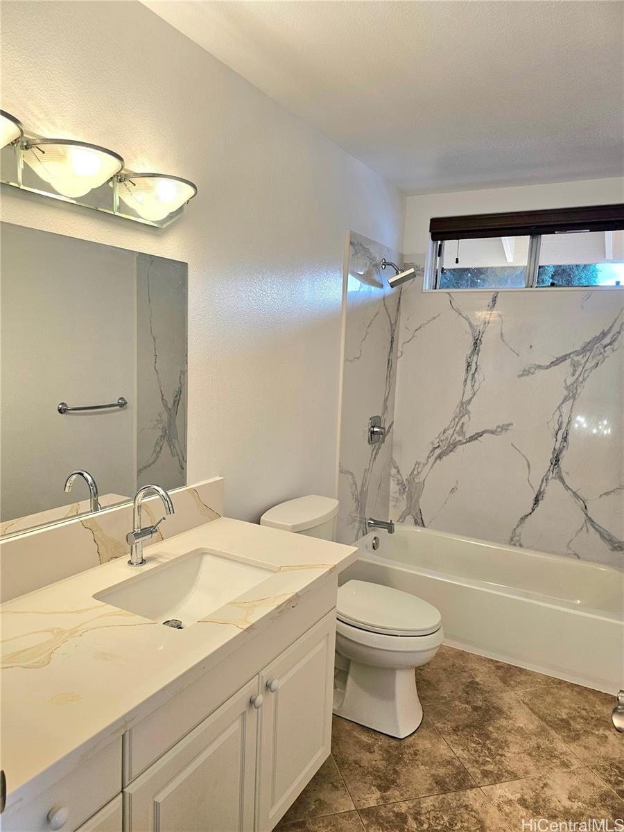 91-1040 Kanihaalilo Street Kapolei, HI 96707 - Photo 12 of 12 a bathroom with a granite countertop sink a toilet and a mirror