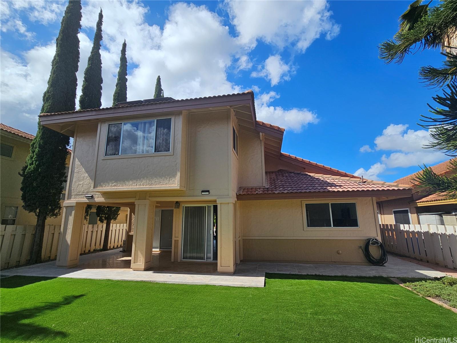91-1040 Kanihaalilo Street Kapolei, HI 96707 - Photo 2 of 12 a front view of a house with a garden and yard