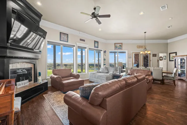 a view of a dining room and livingroom with furniture wooden floor a chandelier