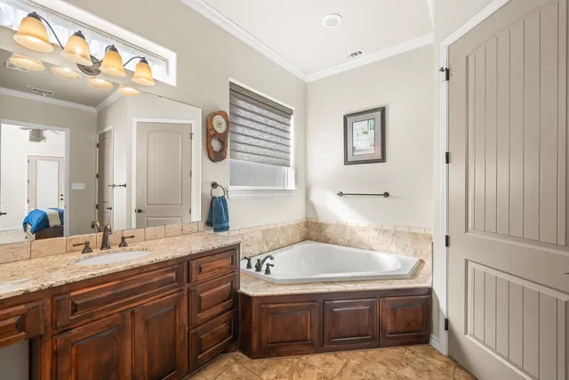 a bathroom with a granite countertop sink a mirror and shower
