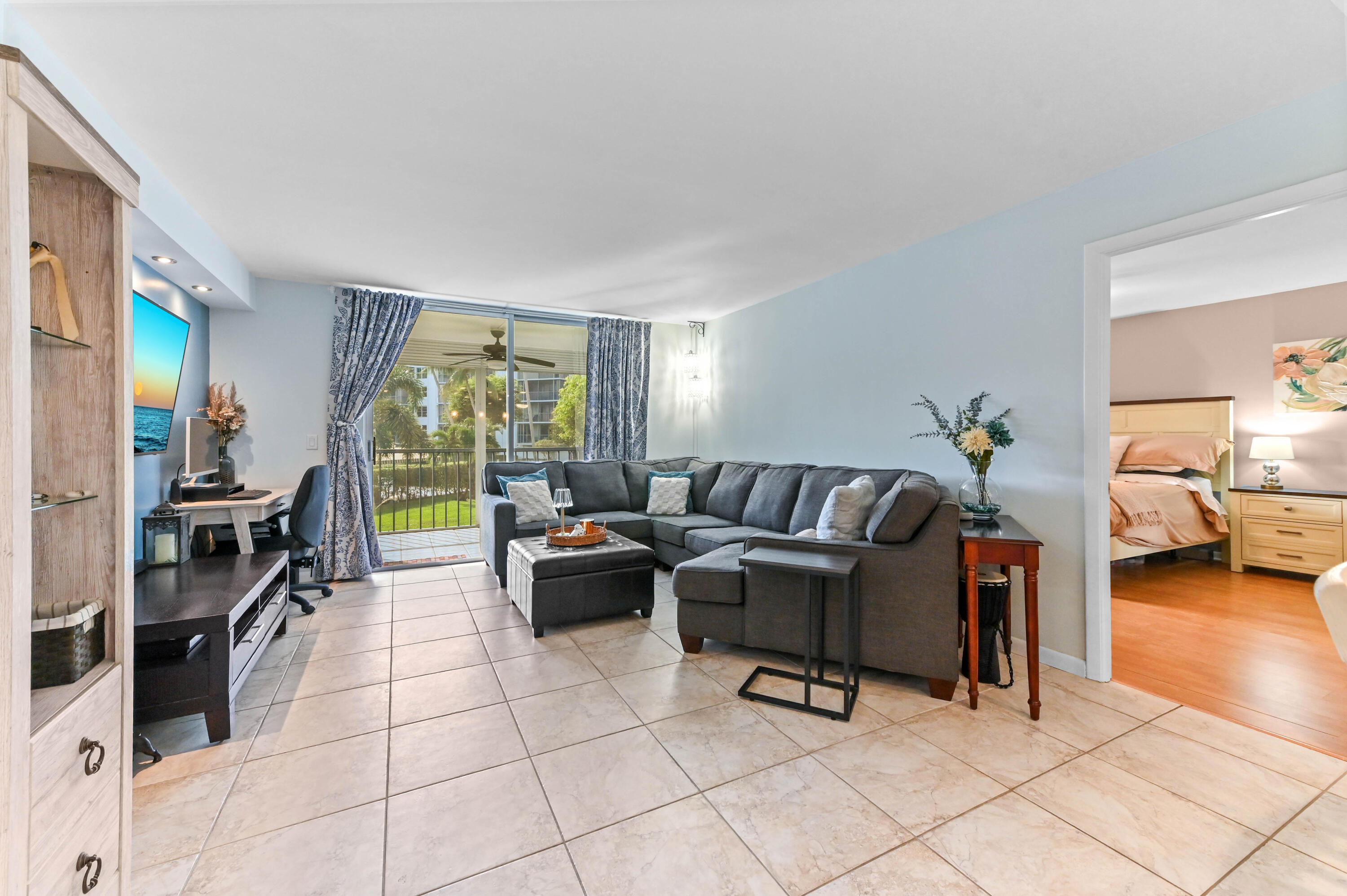198 Northwest 67th Street, Unit 207 Boca Raton, FL 33487 - Photo 15 of 42 a living room with furniture and a flat screen tv