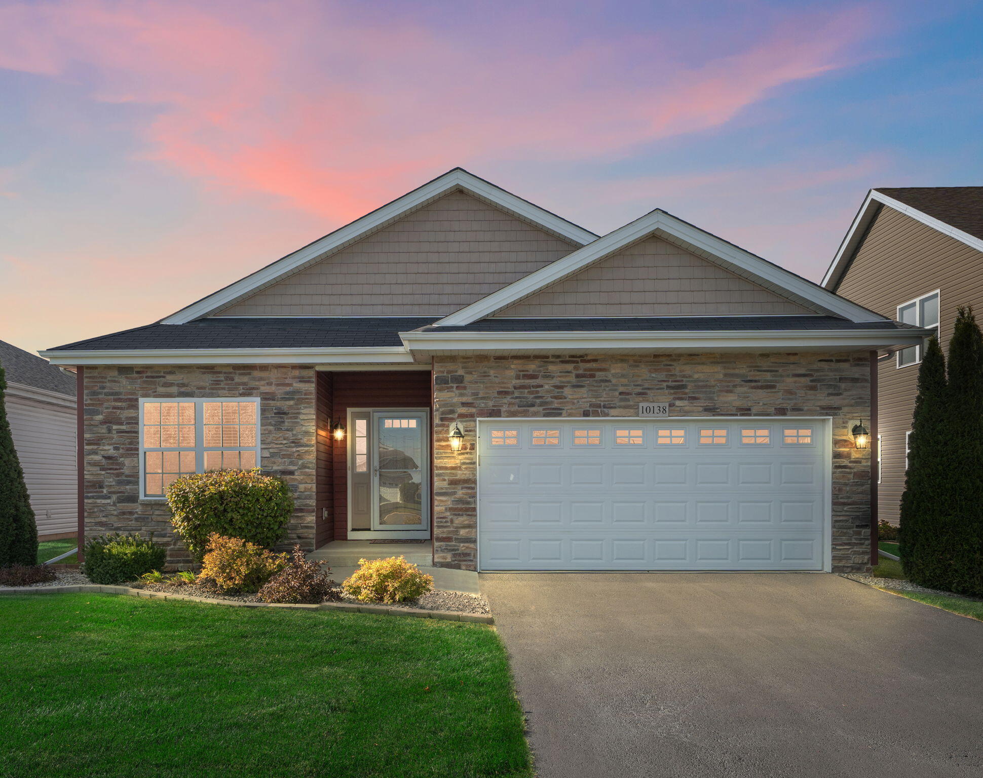 a front view of a house with a yard and garage