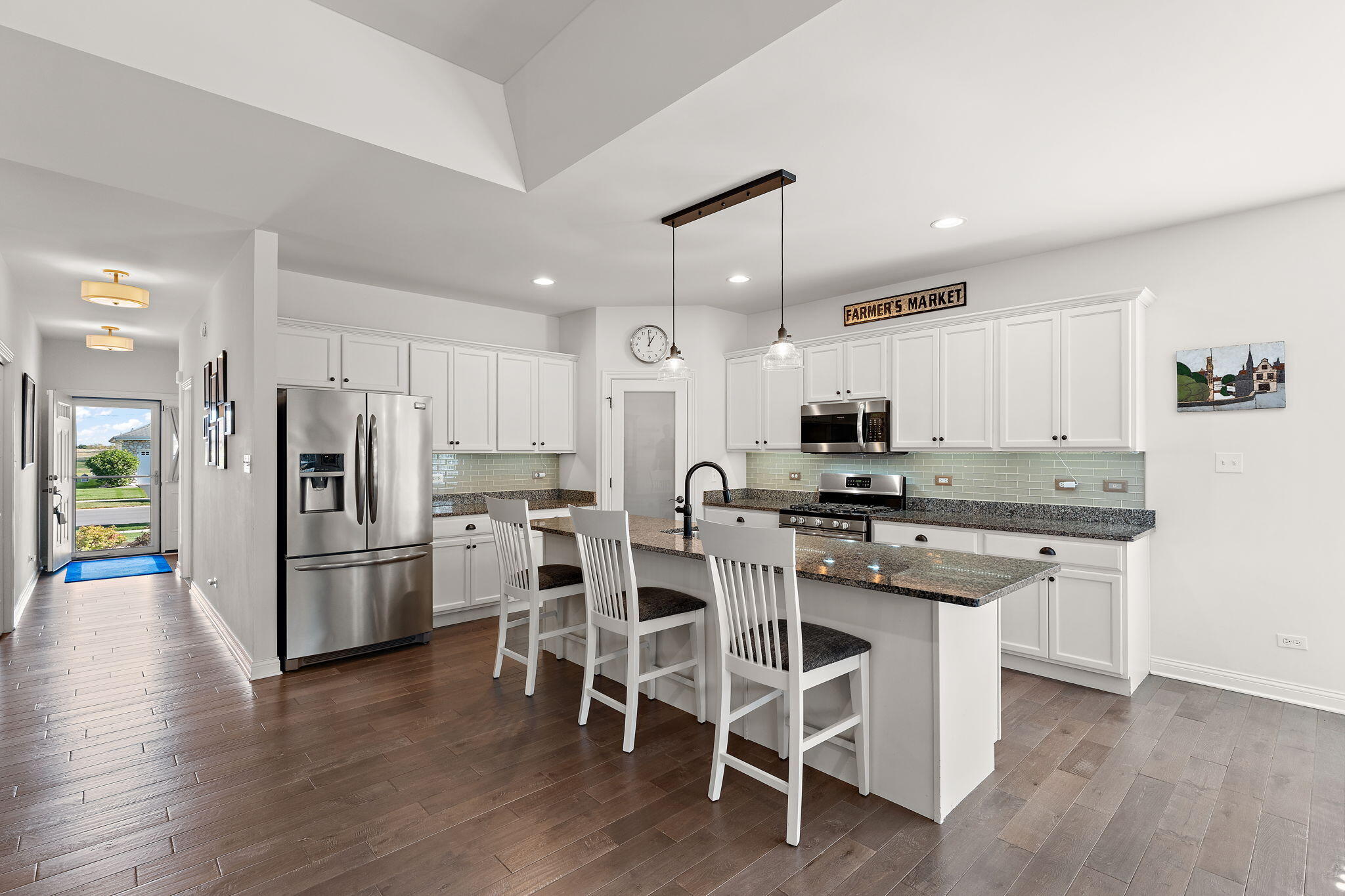 10138 Privet Drive Crown Point, IN 46307 - Photo 2 of 39 a kitchen with stainless steel appliances a refrigerator a stove a sink dishwasher and a dining table with wooden floor