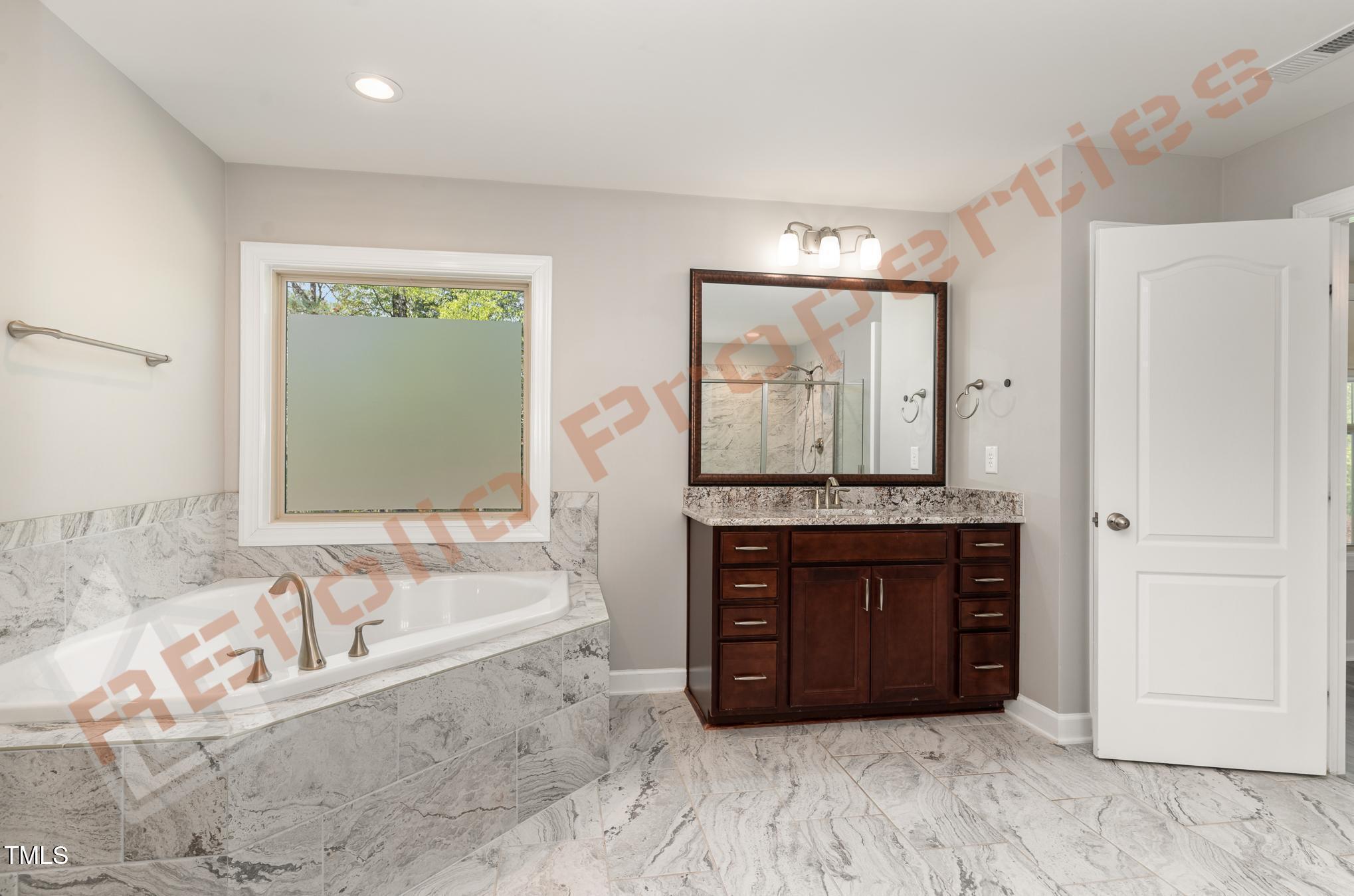 1001 Covered Bridge Trail Chapel Hill, NC 27517 - Photo 17 of 41 a bathroom with a tub a sink and a large window