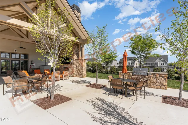 a view of a patio with couches and table and chairs and wooden fence