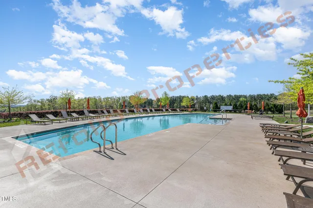 a swimming pool with outdoor seating and lake view