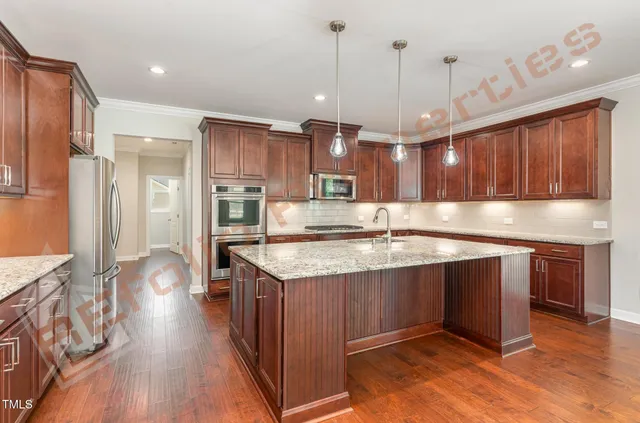 a kitchen with stainless steel appliances granite countertop a sink a stove and a wooden floors