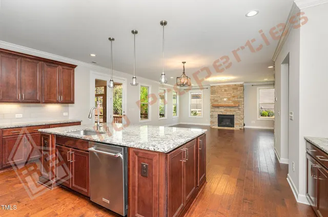 a kitchen with stainless steel appliances granite countertop a sink a stove and a wooden floors