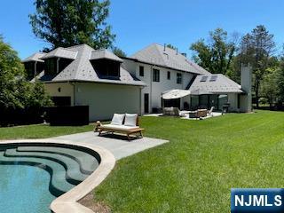 58 Twin Brooks Road Saddle River, NJ 07458 - Photo 33 of 45 a view of a house with backyard sitting area and furniture