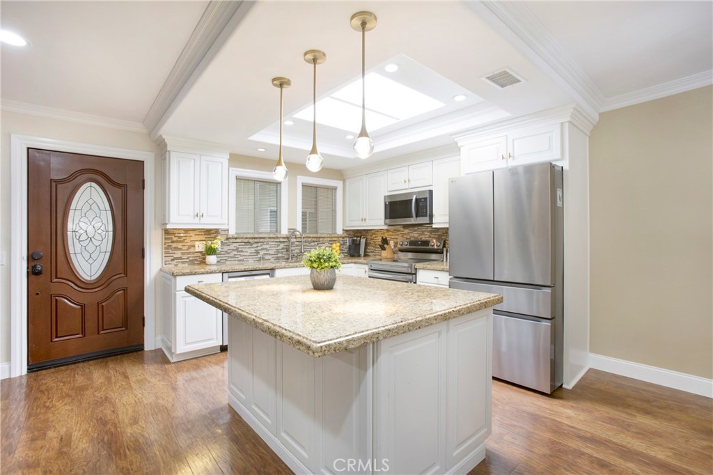 662 Via Los Altos, Unit P Laguna Woods, CA 92637 - Photo 1 of 46 a kitchen with a refrigerator a sink and dishwasher with wooden floor