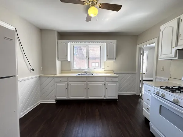 a kitchen with granite countertop a stove a sink and a window