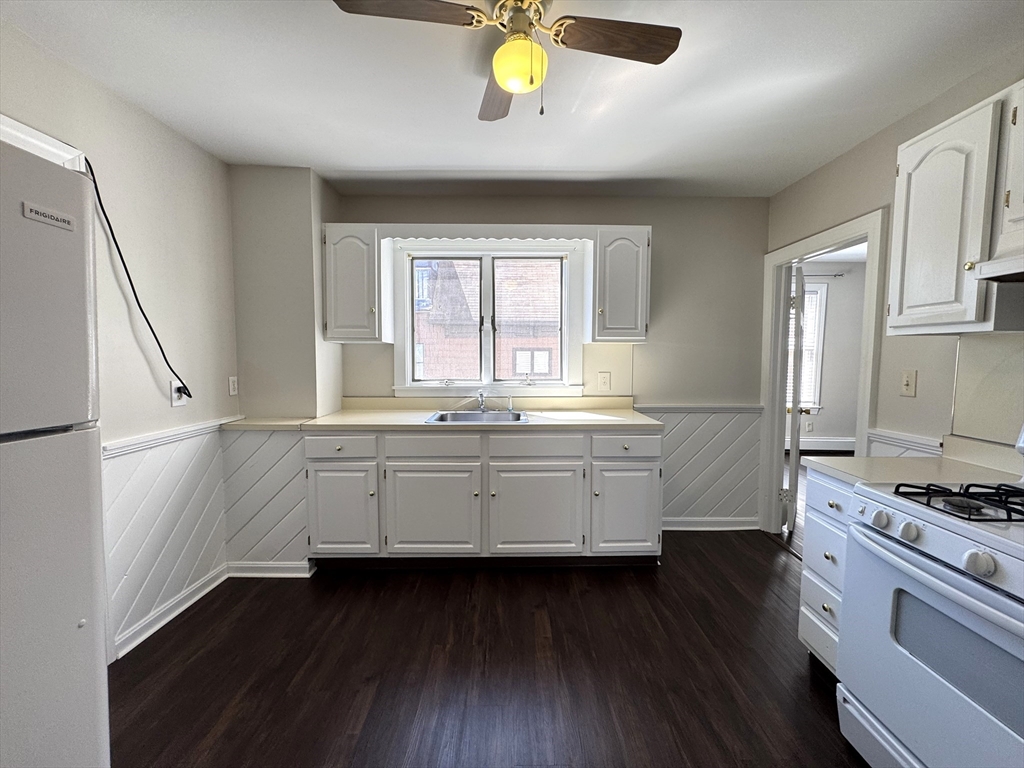 a kitchen with granite countertop a stove a sink and a window