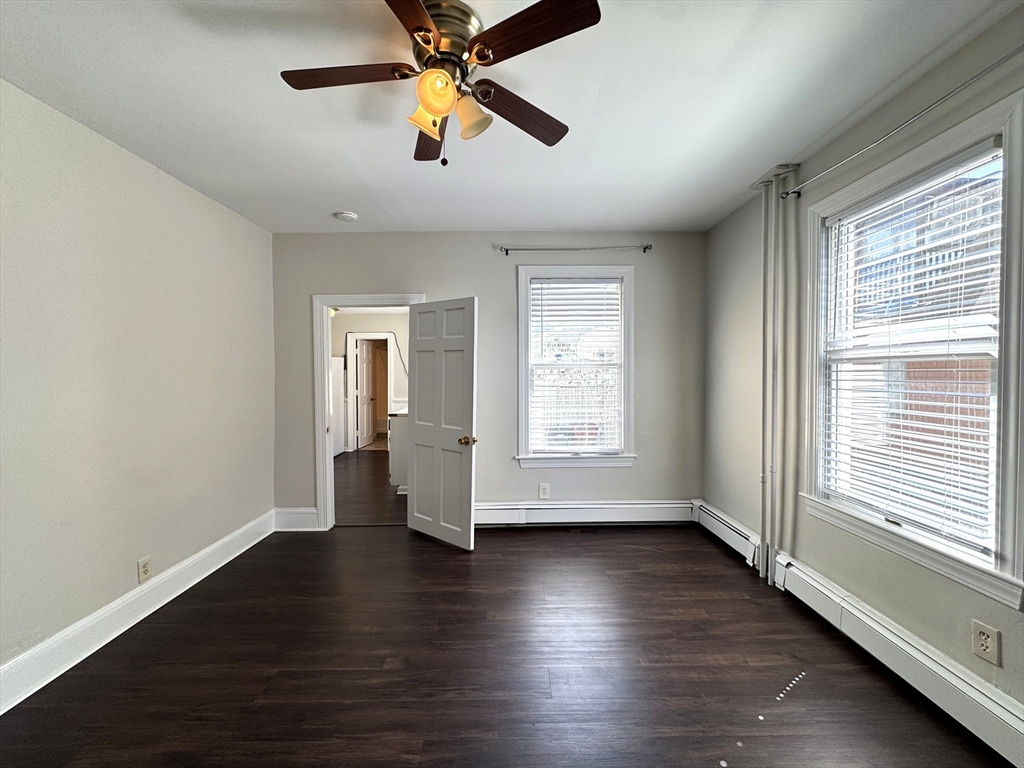 69 Cleveland Avenue, Unit 1 Everett, MA 02149 - Photo 3 of 13 an empty room with wooden floor fan and windows