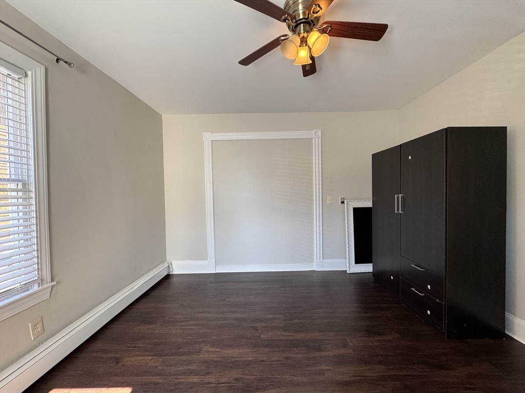 69 Cleveland Avenue, Unit 1 Everett, MA 02149 - Photo 4 of 13 an empty room with wooden floor closet and windows
