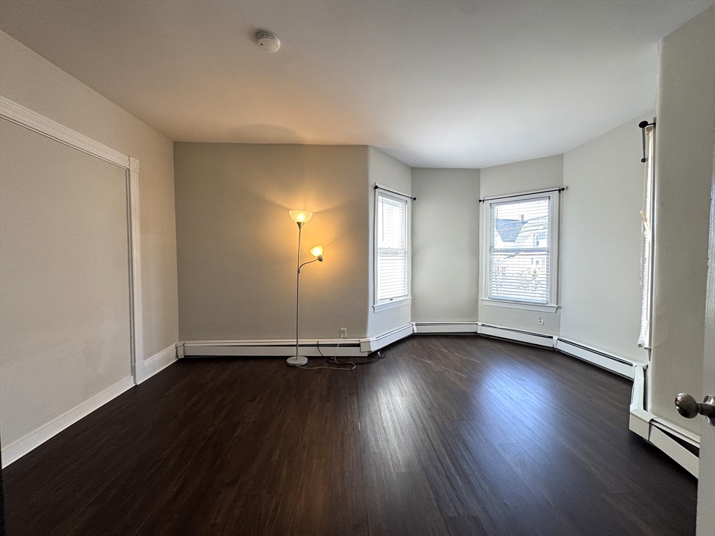 69 Cleveland Avenue, Unit 1 Everett, MA 02149 - Photo 6 of 13 a view of an empty room with wooden floor and window