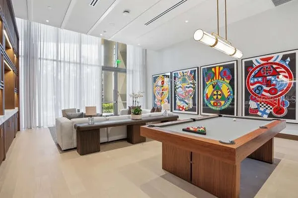 a room with pool table and windows