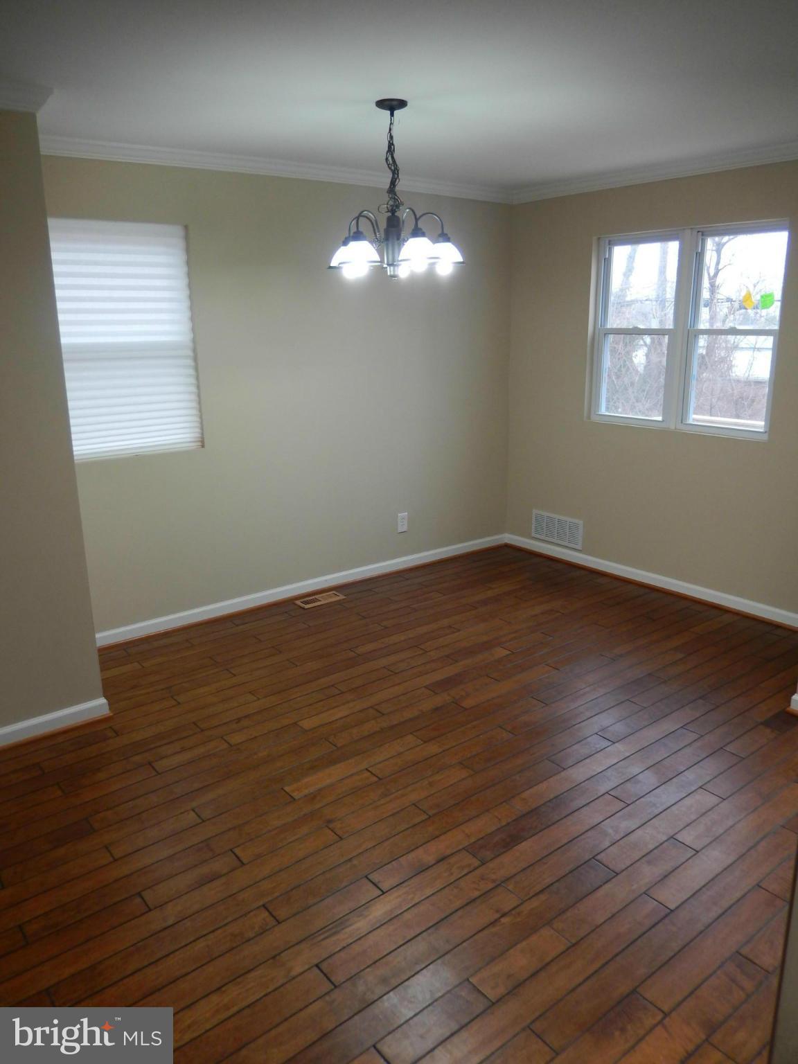 925 Coleridge Road Baltimore, MD 21229 - Photo 5 of 30 wooden floor in an empty room with a window