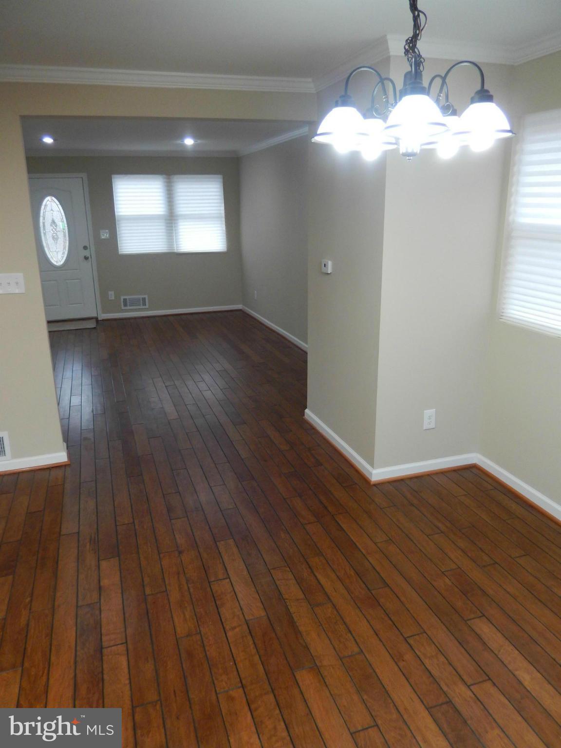 925 Coleridge Road Baltimore, MD 21229 - Photo 6 of 30 an empty room with wooden floor and windows