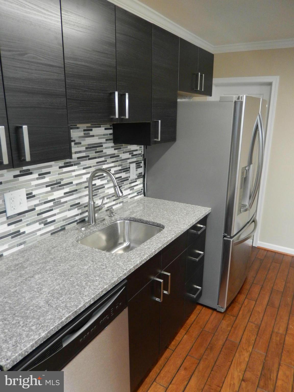 925 Coleridge Road Baltimore, MD 21229 - Photo 10 of 30 a kitchen with stainless steel appliances granite countertop a sink and a refrigerator