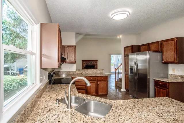 a kitchen with granite countertop a refrigerator and a sink