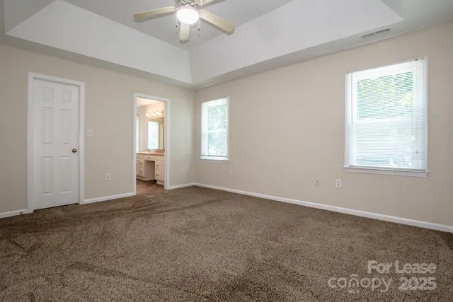 an empty room with windows and fan