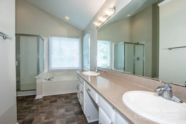 a spacious bathroom with a tub sink and mirror