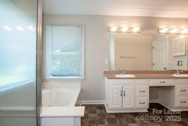 a bathroom with a granite countertop sink a toilet and a mirror