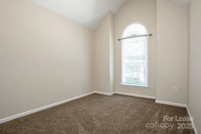 an empty room with window and wooden floor