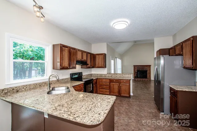 a kitchen with stainless steel appliances granite countertop a sink stove and refrigerator