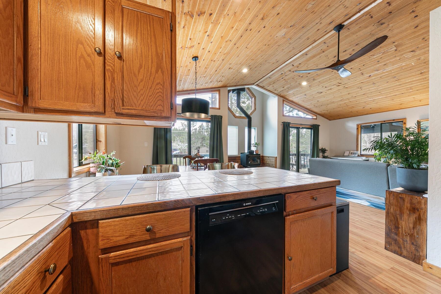 10455 Regency Circle Truckee, CA 96161 - Photo 11 of 28 a kitchen with kitchen island granite countertop a sink and dishwasher with wooden cabinets