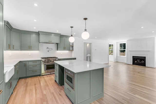 a kitchen with stainless steel appliances granite countertop a stove and a wooden floors