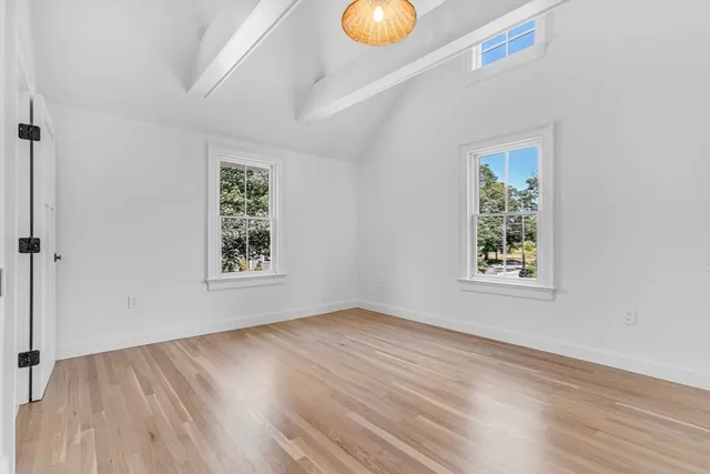 a view of an empty room with wooden floor and closet