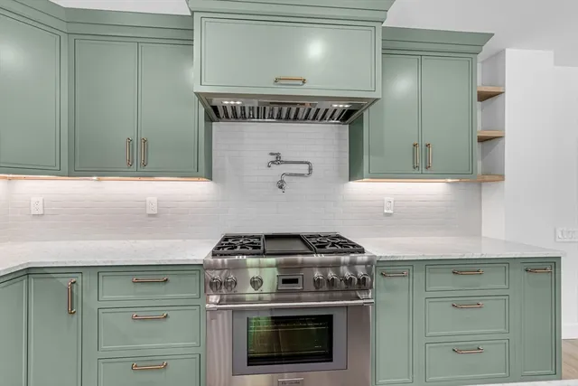 a kitchen with a stove and white cabinets