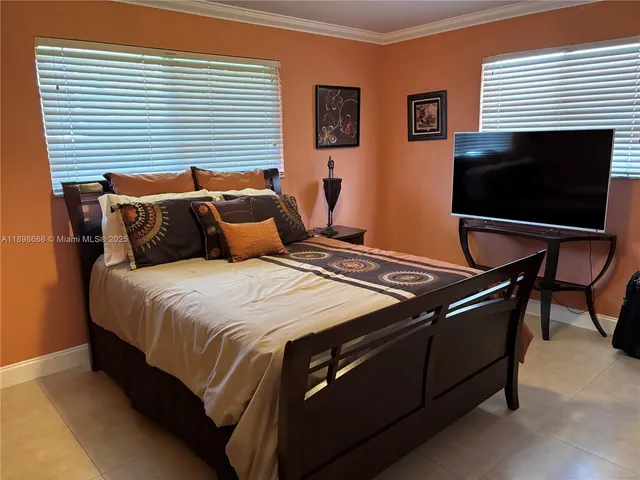 a bed sitting in a bedroom and table chair