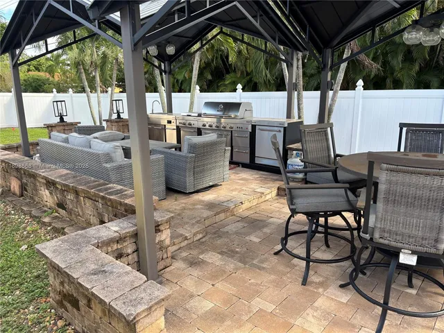 a view of a patio with table and chairs potted plants with wooden floor and fence