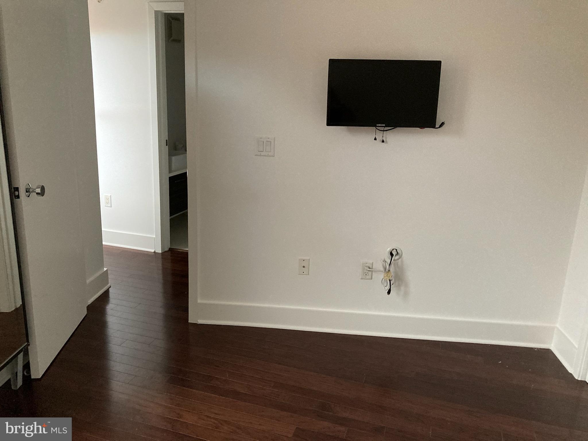1020 Monroe Street Northwest, Unit 204 Washington, DC 20010 - Photo 11 of 30 a view of a livingroom with wooden floor and a flat screen tv