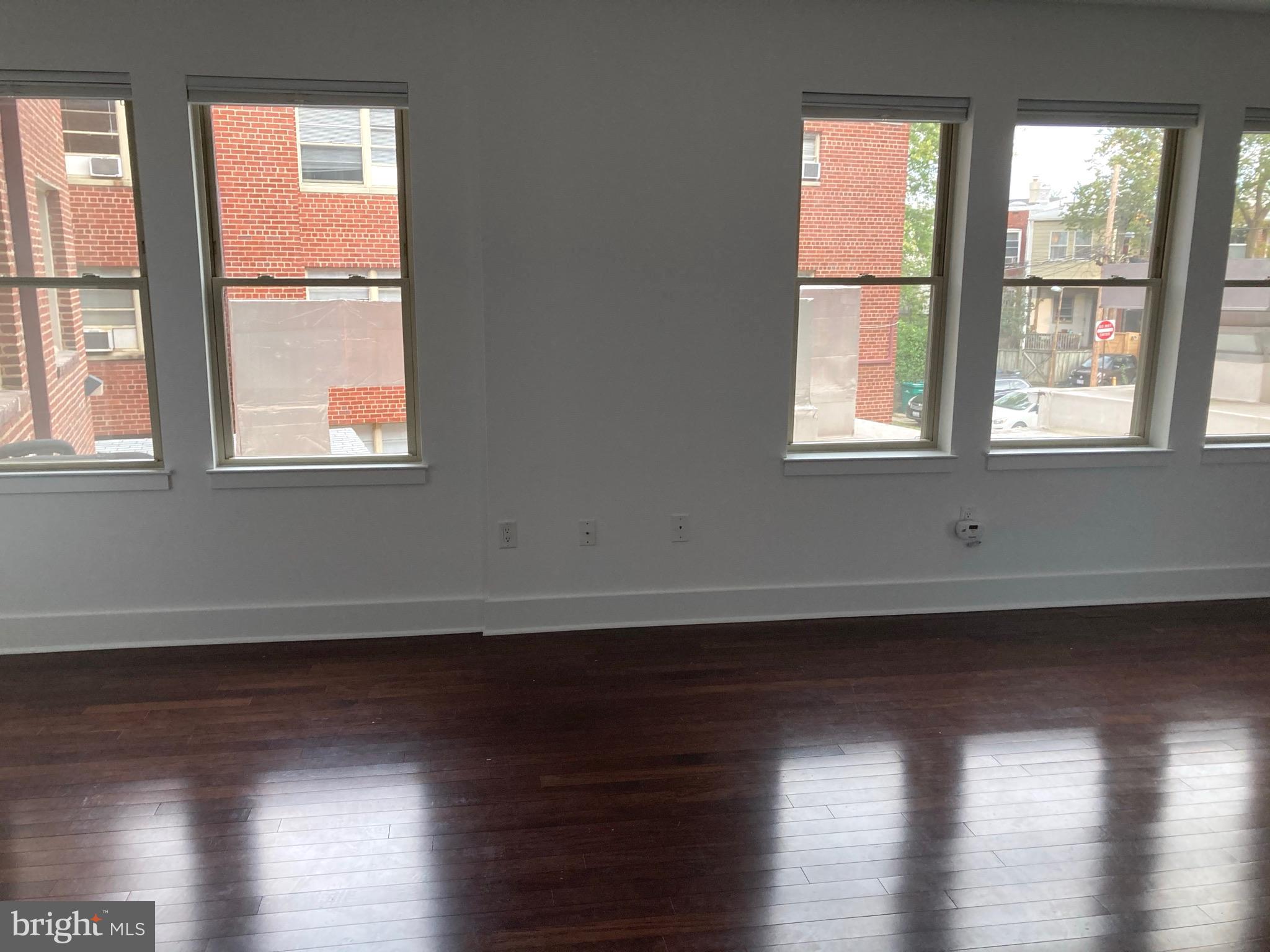 1020 Monroe Street Northwest, Unit 204 Washington, DC 20010 - Photo 2 of 30 an empty room with wooden floor and windows