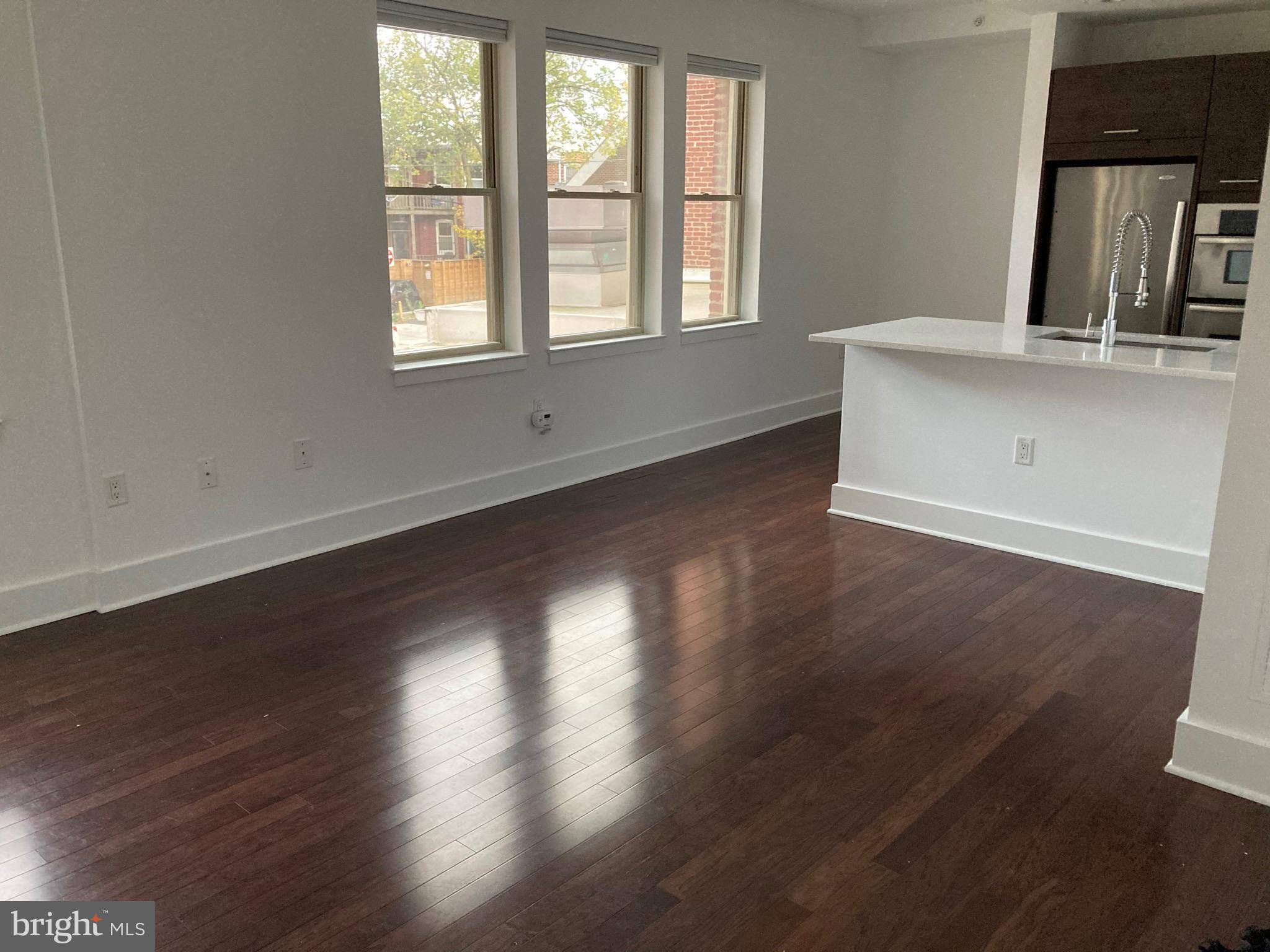 1020 Monroe Street Northwest, Unit 204 Washington, DC 20010 - Photo 3 of 30 an empty room with wooden floor and windows