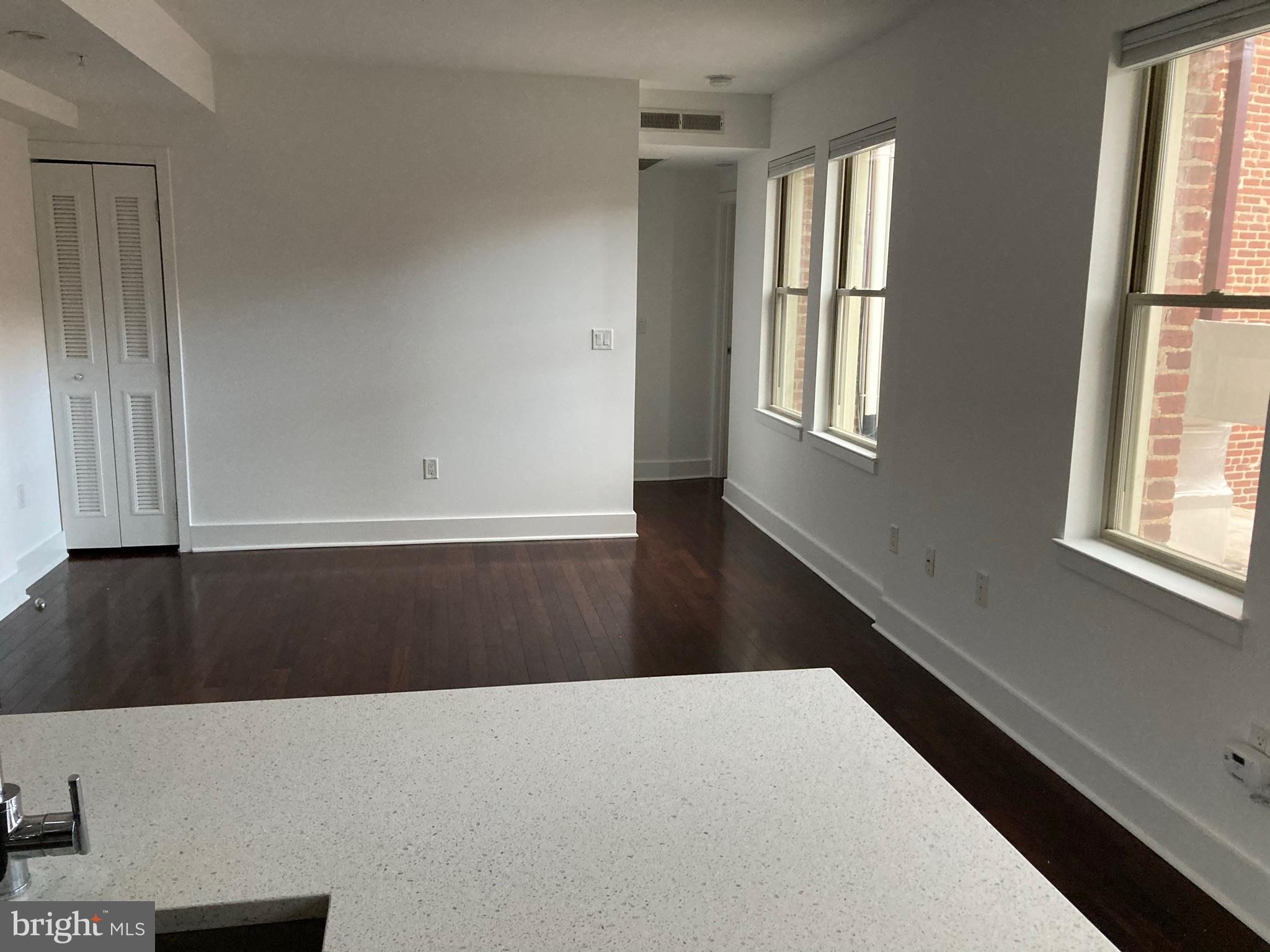 1020 Monroe Street Northwest, Unit 204 Washington, DC 20010 - Photo 4 of 30 a view of an empty room with wooden floor and a window