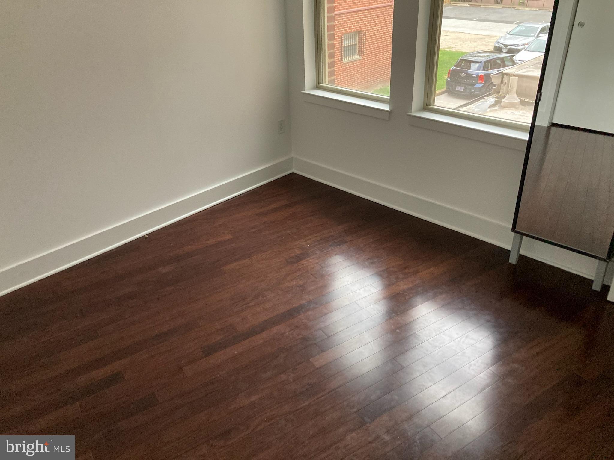 1020 Monroe Street Northwest, Unit 204 Washington, DC 20010 - Photo 10 of 30 an empty room with wooden floor and windows