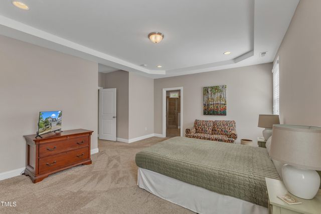 a bedroom with a bed and a lamp on dresser