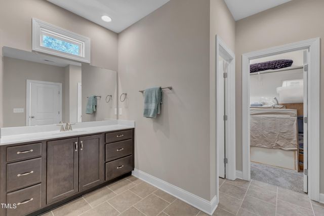 a spacious bathroom with a double vanity sink a mirror and a shower