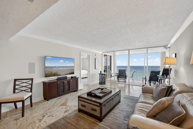a view of a livingroom and dining room with furniture large windows and wooden floor