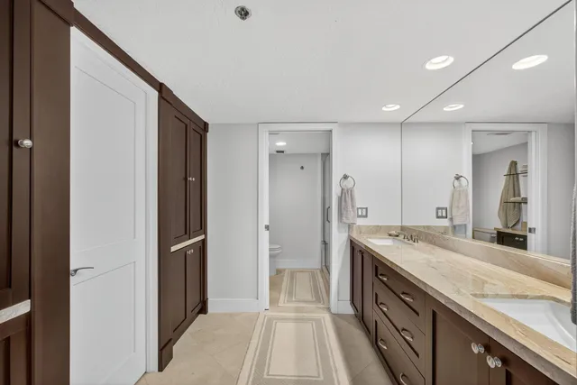 a bathroom with a granite countertop sink toilet and a mirror