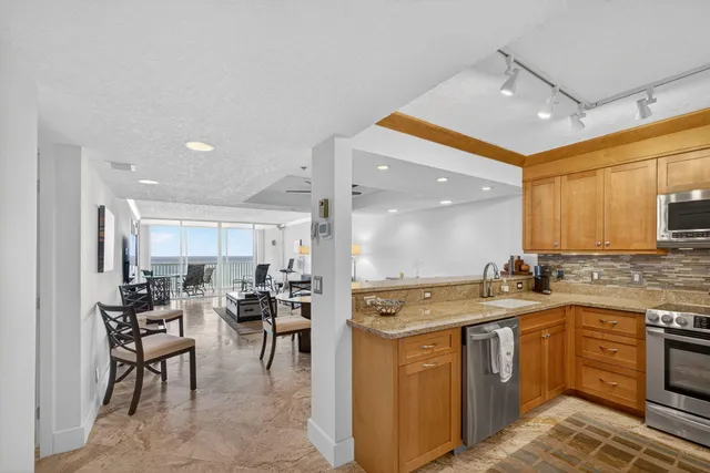 a kitchen with stainless steel appliances granite countertop a sink a stove and a microwave