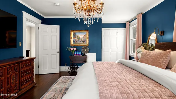 a bedroom with a bed and a chandelier