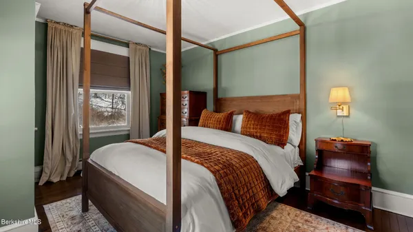 a bedroom with bed and wooden floor