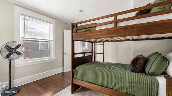 a bedroom with a bed next to a window